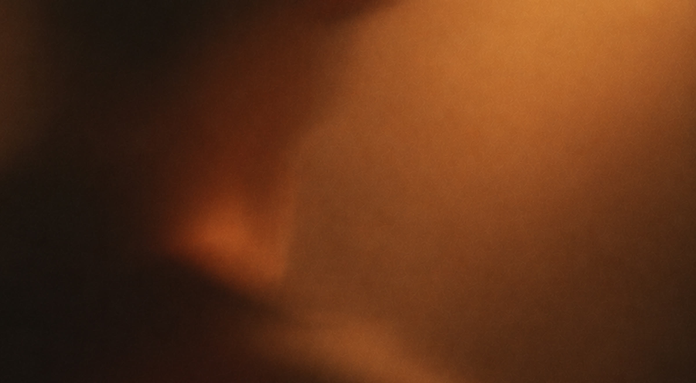 Warm amber light spreading across a dark, softly blurred surface