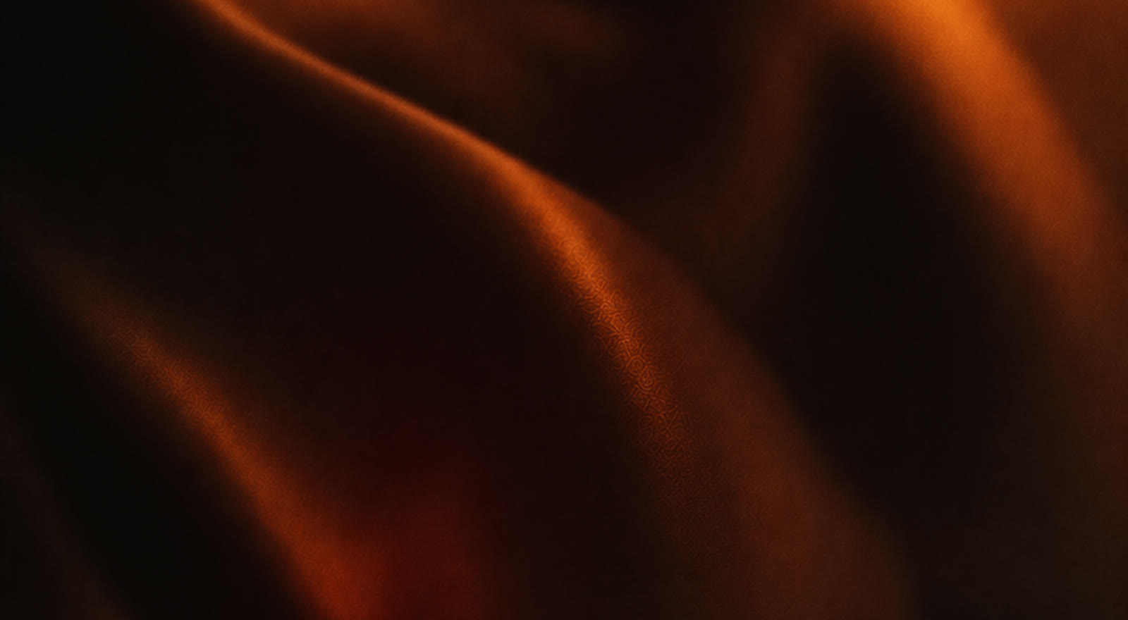 Folds of dark fabric catching warm amber light