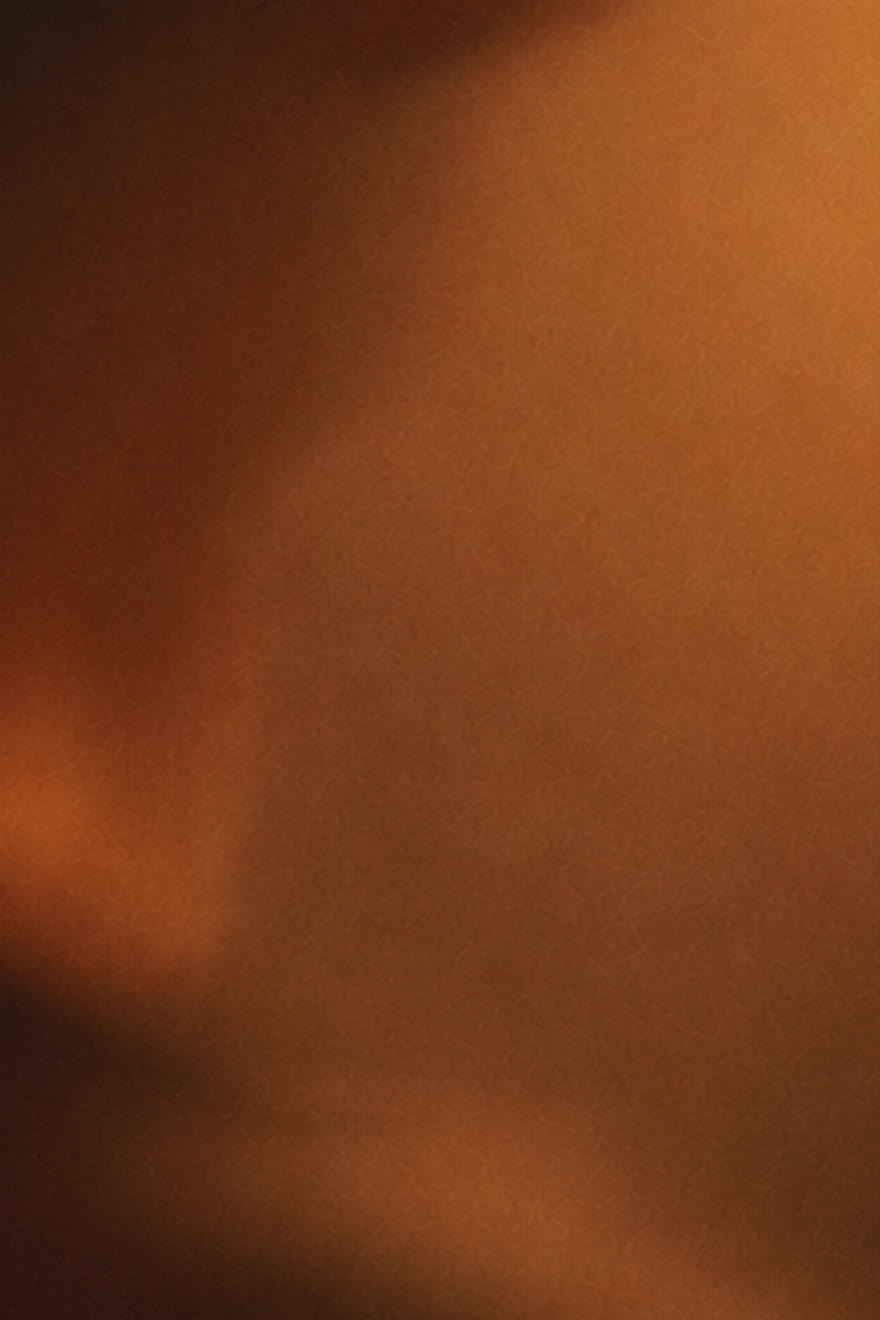 Warm amber light spreading across a dark, softly blurred surface